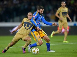 Darío Verón y Pierre Gignac disputan el balón. AFP / P. Pardo