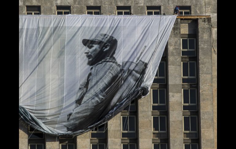 Un hombre despliega una imagen gigante del ex presidente de Cuba, durante los preparativos de su funeral. AP / D. Boylan