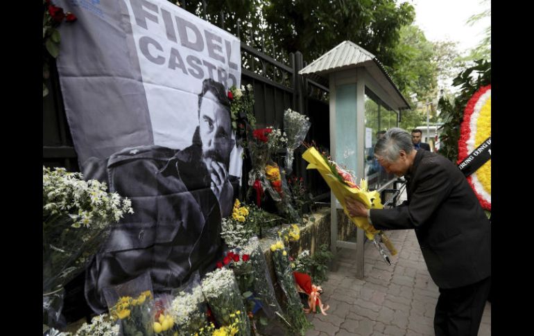 Ciudadanos depositan flores ante la fotografía del líder cubano Fidel Castro. EFE / L. Thai