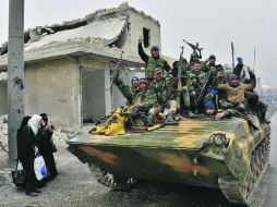 “Victoria”. Fuerzas leales al Gobierno sirio avanzan por una de las derruidas calles de Alepo. AFP /