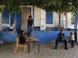 Policías y voluntarios vigilan afuera de uno de los espacios instalados para votar. AP / D. Delay