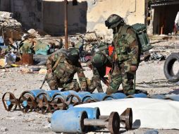 Fuerzas gubernamentales inspeccionan cohetes caseros usados por los rebeldes para sus ataques. AFP / G. Ourfalian
