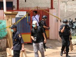 Policías hacen guardia afuera de la casa donde se hallaron los explosivos. AFP / B. Mahameru