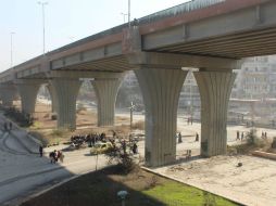 Habitantes de los barrios orientales de Aleppo caminan bajo el puente al-Sakhour hacia las áreas controladas por autoridades. EFE / STR