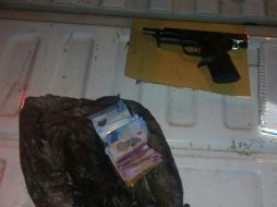 Al ver los policías, el sospechoso tira el arma a un pastizal cercano, pero es recuperada junto al dinero tras su detención. ESPECIAL / Policía de San Pedro Tlaquepaque