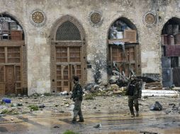 Efectivos gubernamentales caminan por entre las calles de Alepo, en calma por primera vez desde noviembre. AP / SANA