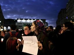 Una mujer sostiene un cartel que dice 'Mantengan a sus mártires en alto' durante un homenaje a las víctimas del más reciente ataque. AP / N. El-Mofty
