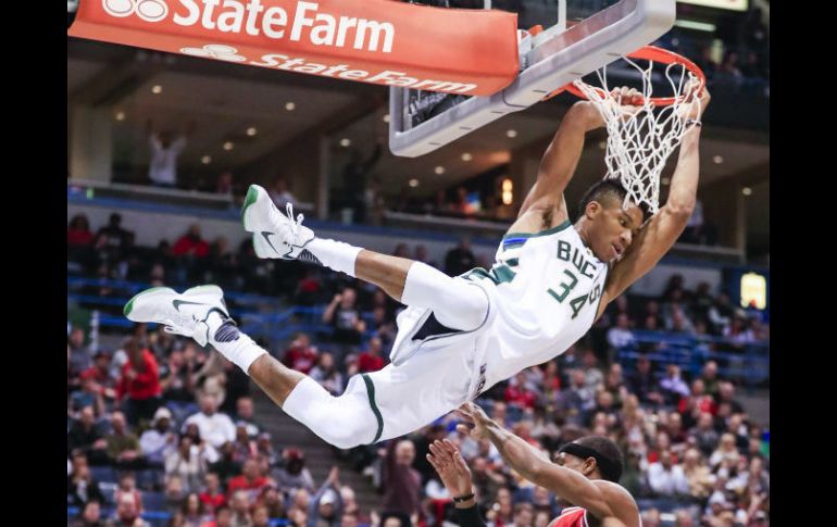 Giannis Antetokounmpo clava el balón ante la marca de Rajon Rondo, durante el partido de ayer. EFE / T. Maury