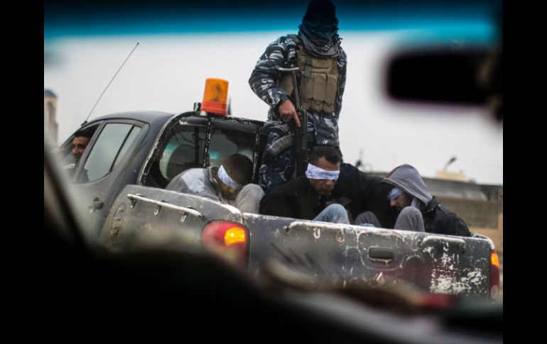 Un miembro de las fuerzas iraquíes traslada a cuatro presuntos miembros del EI tras un combate. AFP / J. Lopez