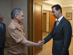 El ministro de Defensa ruso, Serguéi Shoigu (i), estrecha la mano de Bachar al Asad (d) durante una reunión. AP / V. Savitsky