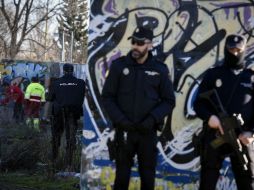 Agentes permanecen en las inmediaciones de la cabaña situada en el barrio de Vallecas, donde ocurre el registro. EFE / F. Villar