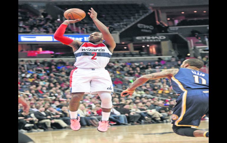 La figura. John Wall (#2) realiza un tiro ante la mirada de  Monta Ellis, de los Pacers. AP /