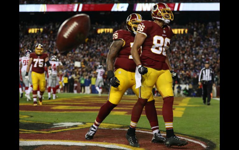 Jordan Reed (86) de los Gigantes celebra con su compañero Morgan Moses después de una anotación en el último cuarto. AFP / P. SMITH