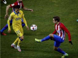 Griezmann (D), del Atlético de Madrid golpea el balón, vigilado por Lópes (I), de Las Palmas. EFE / J. Martin
