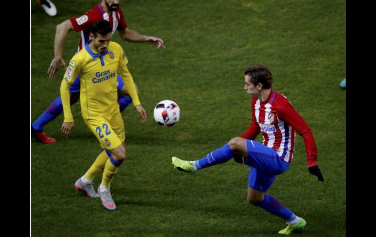 Griezmann (D), del Atlético de Madrid golpea el balón, vigilado por Lópes (I), de Las Palmas. EFE / J. Martin