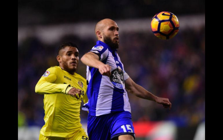 Dos Santos (I) pugna por un balón con Sanabria (D), de La Coruña. AFP / M. Riopa