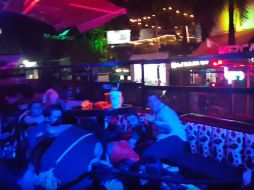 Imagen del momento en el que asistentes al Blue Parrot se refugian entre los muebles por las detonaciones. EFE / M. Vázquez