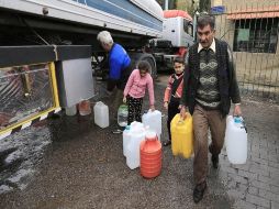 Habitantes usan recipientes de plástico para recabar el agua que les reparten a través de camiones cisterna. AP / H. Ammar