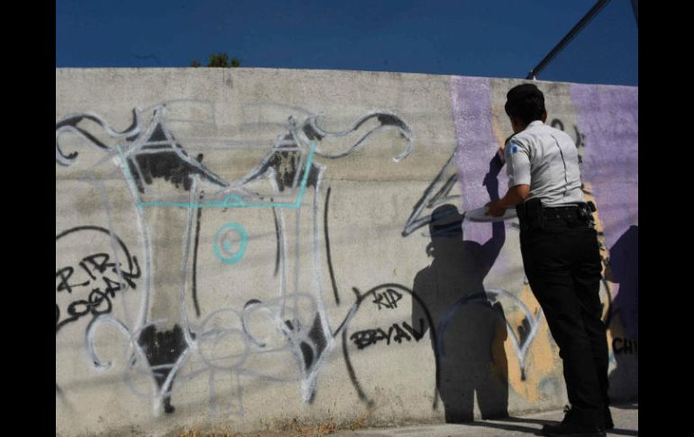 Muchas áreas han sido pintadas con grafitis de los pandilleros, pero con apoyo de vecinos están repintando paredes, muros y casas. AFP / J. Ordonez
