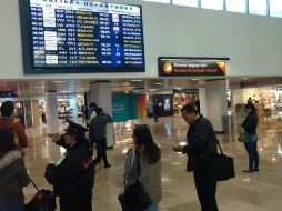 Cientos de pasajeros deambulan por las salas de espera en las que se escuchan constantes cambios de horarios de salida. EL INFORMADOR /