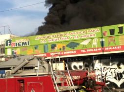 Bomberos tuvieron que cerrar calles aledañas a la bodega para combatir el incendio. ESPECIAL /