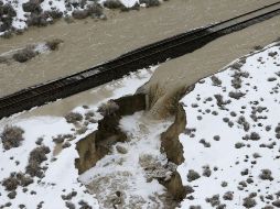 Las fuertes lluvias provocaron el estallamiento de una presa de tierra conglomerada, causando destrozos en la carretera estatal. AP / S. Johnson