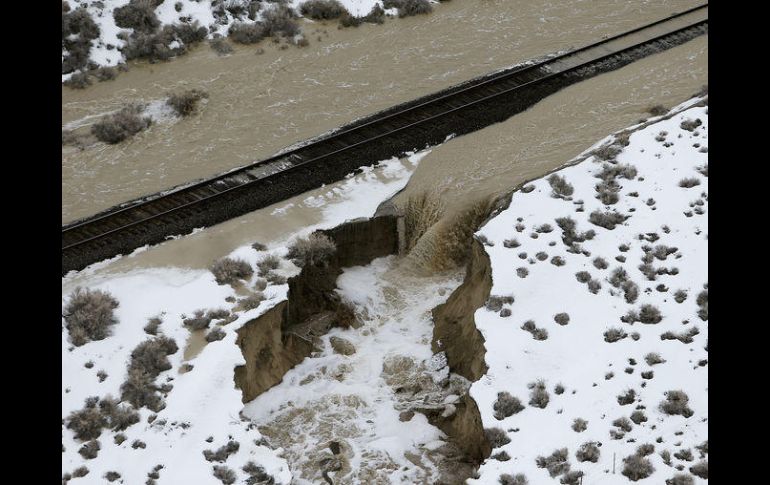 Las fuertes lluvias provocaron el estallamiento de una presa de tierra conglomerada, causando destrozos en la carretera estatal. AP / S. Johnson