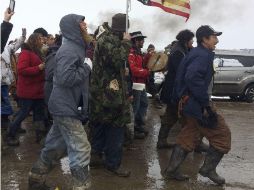 En Dakota, Cerca de 150 personas marcharon codo a codo al salir del lodoso campamento, cantando y tocando tambores mientras caminaban. AP / B. Nicholson