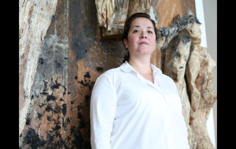 Mónica Ashida, curadora responsable de la exposición, al lado de la obra 'Aquelarre', de Germán Venegas. EL INFORMADOR / G. Gallo