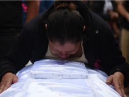 Rosa María Tobar, madre de la niña Rosa Espino Tobar, llora sobre el ataúd donde está el cuerpo de su hija. EFE / E. Bercián