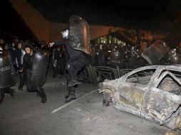 Centenares de manifestantes volcaron coches de la policía, lanzaron piedras a los agentes y rompieron numerosas vitrinas. AP / S. Baroyan