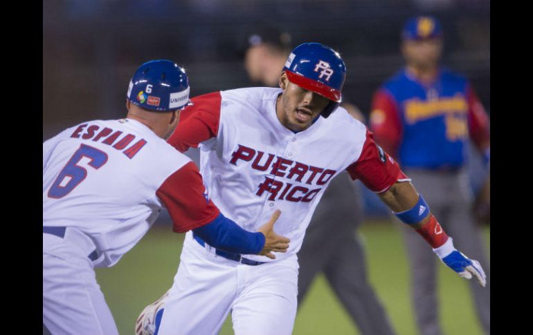Carlos Correa, de Puerto Rico, sacó la esférica del parque con dos de sus compañeros en las bases. MEXSPORT / C. de Marchena