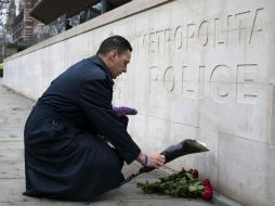 Un ciudadano deposita unas flores a las afueras de la sede de Scotland Yard en Londres. EFE / W. Oliver