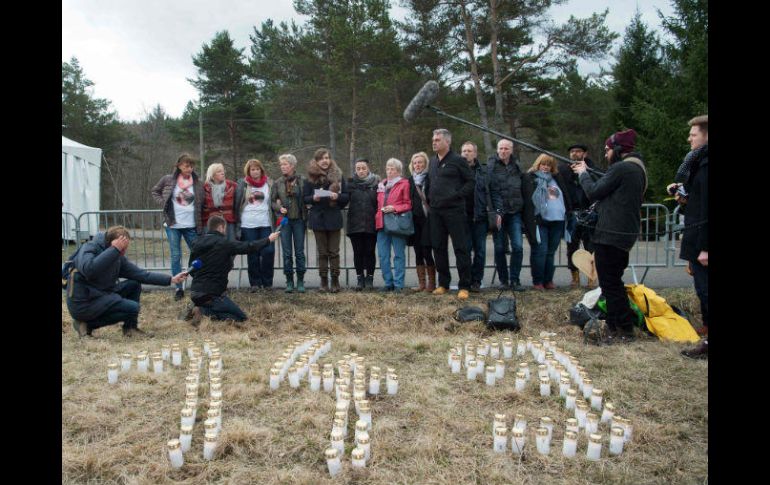 Familiares y amigos de las víctimas formaron con velas el número de víctimas. AFP / B. Langlois