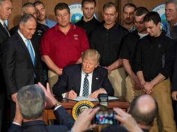 Donald Trump, acompañado de Scott Pruitt, jefe de la Agencia de Protección Ambiental, y un grupo de mineros. AFP / J. Watson