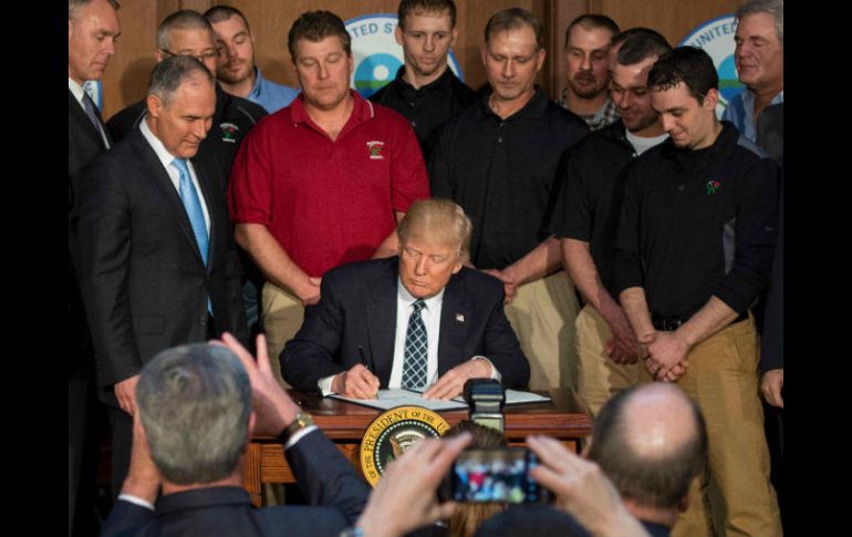 Donald Trump, acompañado de Scott Pruitt, jefe de la Agencia de Protección Ambiental, y un grupo de mineros. AFP / J. Watson