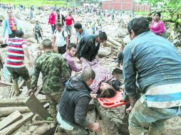 Policías, militares y civiles brindan apoyo a los afectados por la emergencia en Mocoa, donde la inundación afectó 17 barrios. AFP /