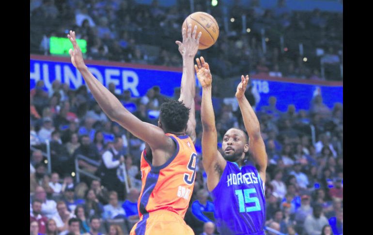 Kemba Walker (derecha) realiza un tiro ante la marca de Jerami Grant. AP / S. Ogrocki