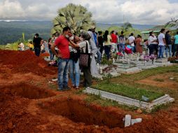 Con los rostros desencajados, decenas de personas asistieron al entierro colectivo de las víctimas de la avalancha. EFE / L. Muñoz