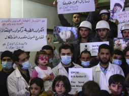 Niños sirios, voluntarios y personal de servicios de primeros auxilios expresan su solidaridad con las víctimas del ataque químico. EFE / M. Badra