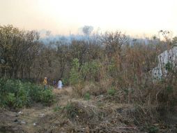 Con apoyo de helicópteros, bomberos siguen combatiendo el fuego. ESPECIAL /