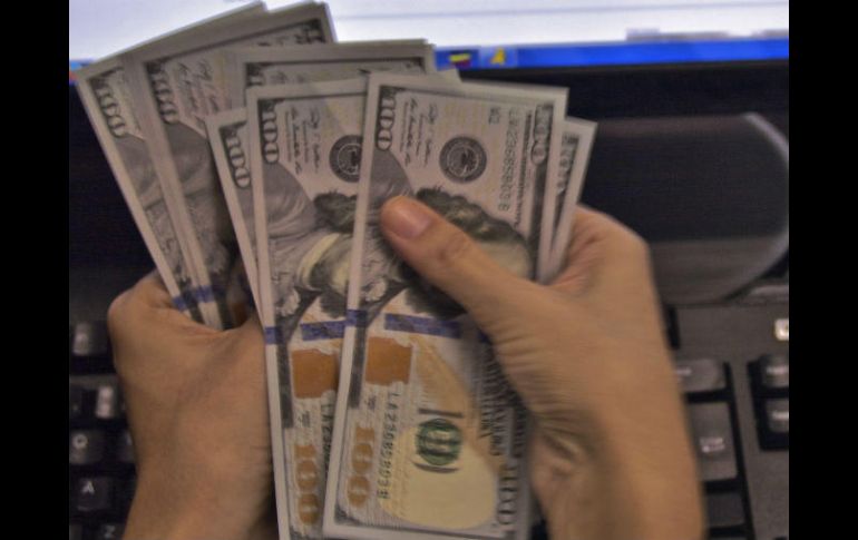 El billete verde se compra en un mínimo de 17.70 pesos en bancos de la capital. AFP / ARCHIVO
