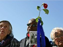 Un hombre levanta una fotografía de los hermanos Marto en la procesión por el 90 aniversario de la aprición mariana, en 2007. AFP / F. Leong