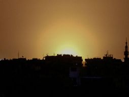 Una foto tomada de la ciudad de Douma muestra llamas que se elevan a la distancia que se cree provienen del Aeropuerto de Damasco. AFP / S. Al-Doumy