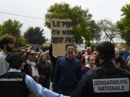 La aspirante no llegó a recibir el impacto de ningún objeto gracias a la protección de su equipo. AFP / D. Meyer