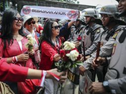Simpatizantes de Basuki Tjahaja Purnama entregan rosas a policías antidisturbios. EFE / M. Irham