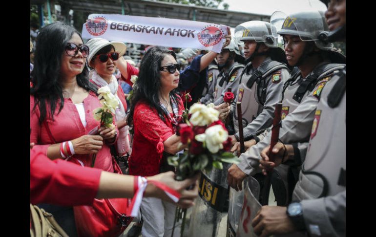 Simpatizantes de Basuki Tjahaja Purnama entregan rosas a policías antidisturbios. EFE / M. Irham