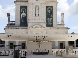 Las imágenes de Jacinta (i), y Francisco Marto (d), cuelgan en la fachada del Santuario de Nuestra Señora de Fátima. AP / A. Franca