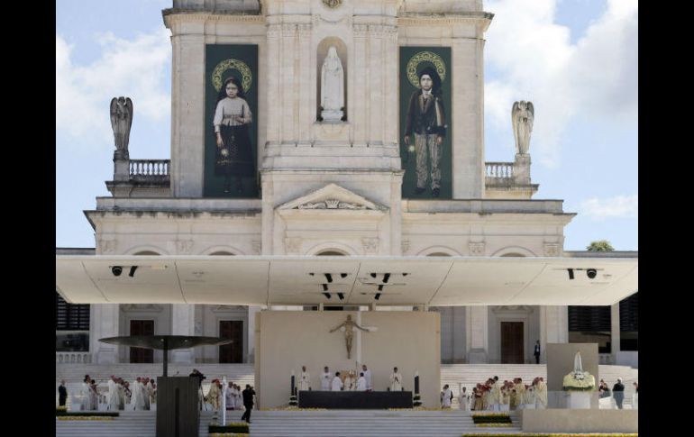 Las imágenes de Jacinta (i), y Francisco Marto (d), cuelgan en la fachada del Santuario de Nuestra Señora de Fátima. AP / A. Franca