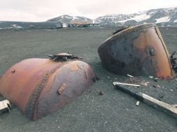 Recipientes que contenían partes de las ballenas para procesarse yacen semienterrados en lava volcánica. ESPECIAL /